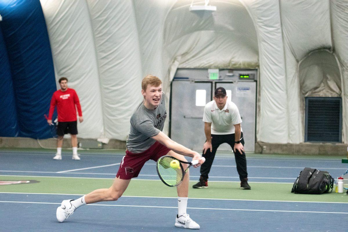 Nathan Tjelle returns a ball close to the net in his doubles match against LC State at Whitworth University, Saturday, March 19, 2022, in Spokane, Wash. | Thomas Peach/The Whitworthian