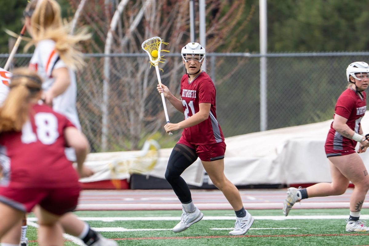 Whitworth attacker #21 Campbell Vincent runs looks for an open goal-ward pass, Saturday, April 19, 2025, at an NCAA Women's Lacrosse game against Lewis and Clark College at the Whitworth Pine Bowl in Spokane, Wash. | Caleb Flegel/The Whitworthian